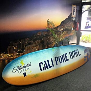 A graphic applied to a surfboard advertising for an event