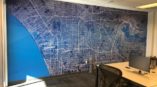A wall mural with a broad map of a city