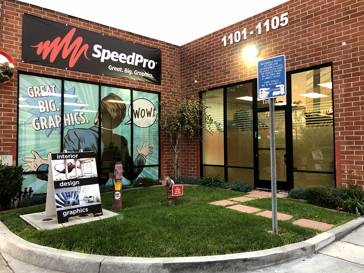 Banner, a-frame, and window graphic at the entrance to SpeedPro Imaging studio
