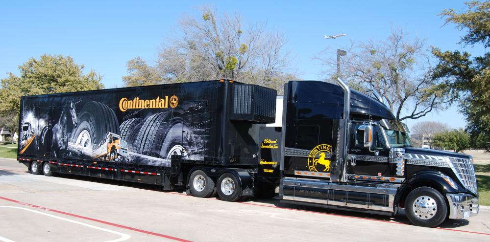 A custom fleet wrap on a black tractor trailer and the graphic says Continental