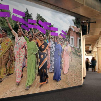 A custom banner display of people walking through a village
