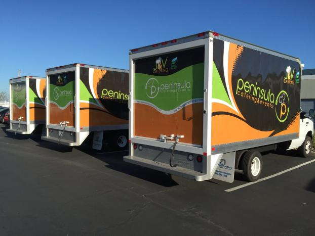 Multiple vehicle wraps displayed on box trucks for Peninsula Catering & Events