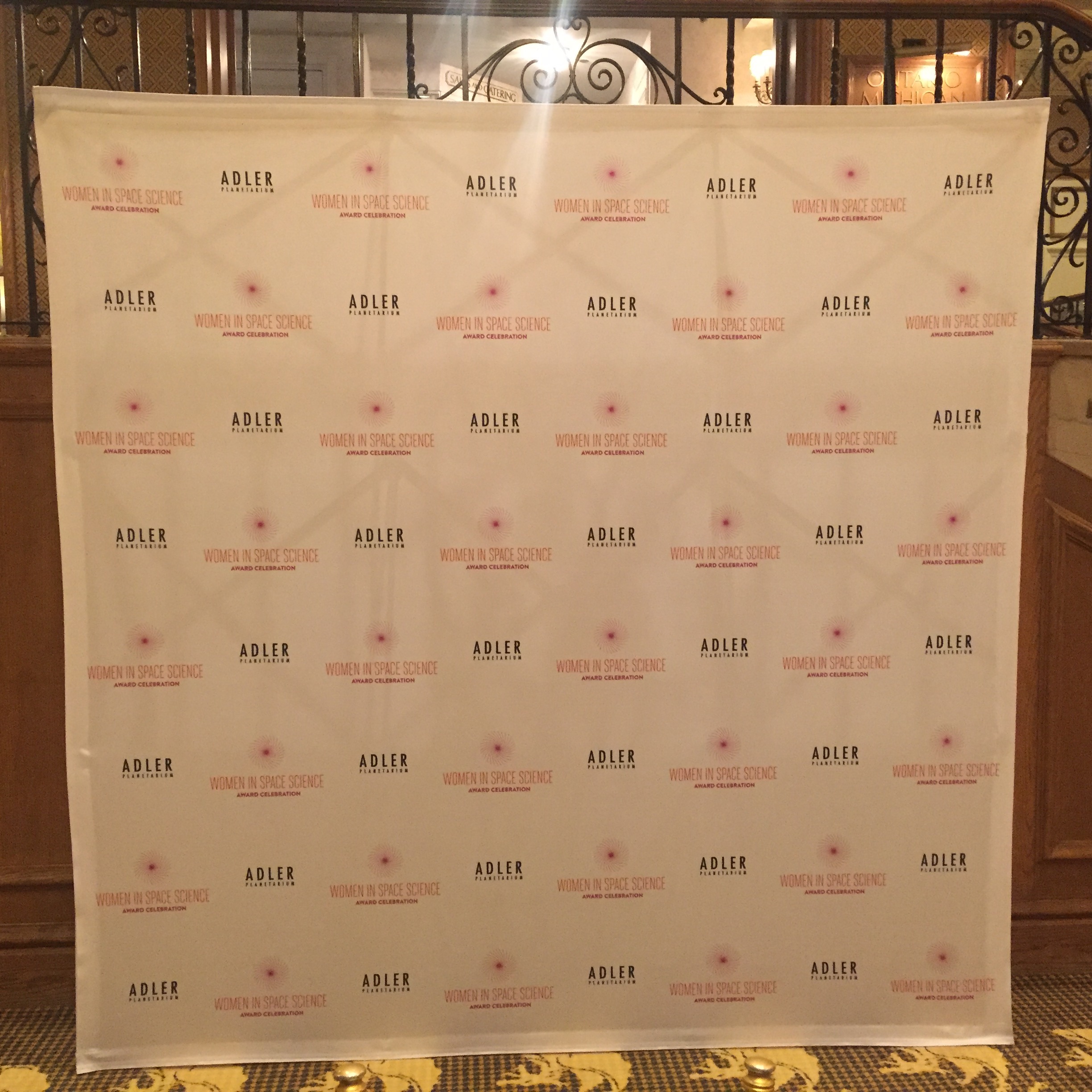 A step and repeat banner for Adler and Women in Space Science