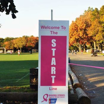 An outdoor sign that says welcome to the start line at an American Cancer Society breast cancer event.