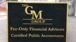 Logo for The GM Group on plaque. Service offerings are financial advisors and CPAs.