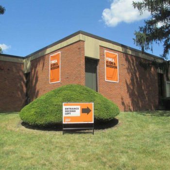 2 outdoor signs on a building advertising the YWCA and another sign pointing to the YWCA entrance