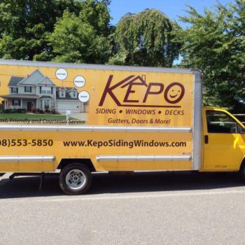 Vehicle wrap on a large, yellow truck for Kepo siding, windows, and doors with home image.