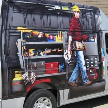 A vehicle is wrapped to advertise for Nissan Commercial Vehicles and features a man in a hard hat next to a tool bench