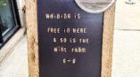 A sidewalk sign advertising free wine at Craft and Barrel