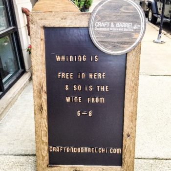 A sidewalk sign advertising free wine at Craft and Barrel