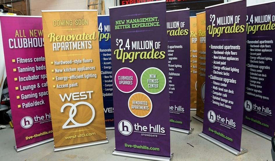 Multiple retractable banners advertising a recently renovated apartment complex