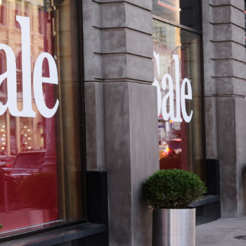 Window graphics advertising a sale with white letters and a red background