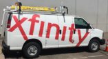 White van wrapped with red Xfinity text