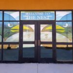 Window signage with phrase welcome to the nest