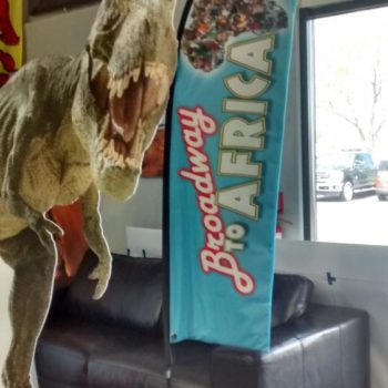Broadway to Africa flag next to T-rex cut out