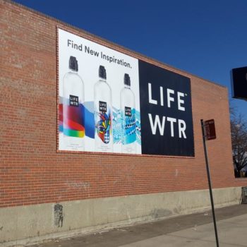 Life Wtr advertisement hanging on side of brick building
