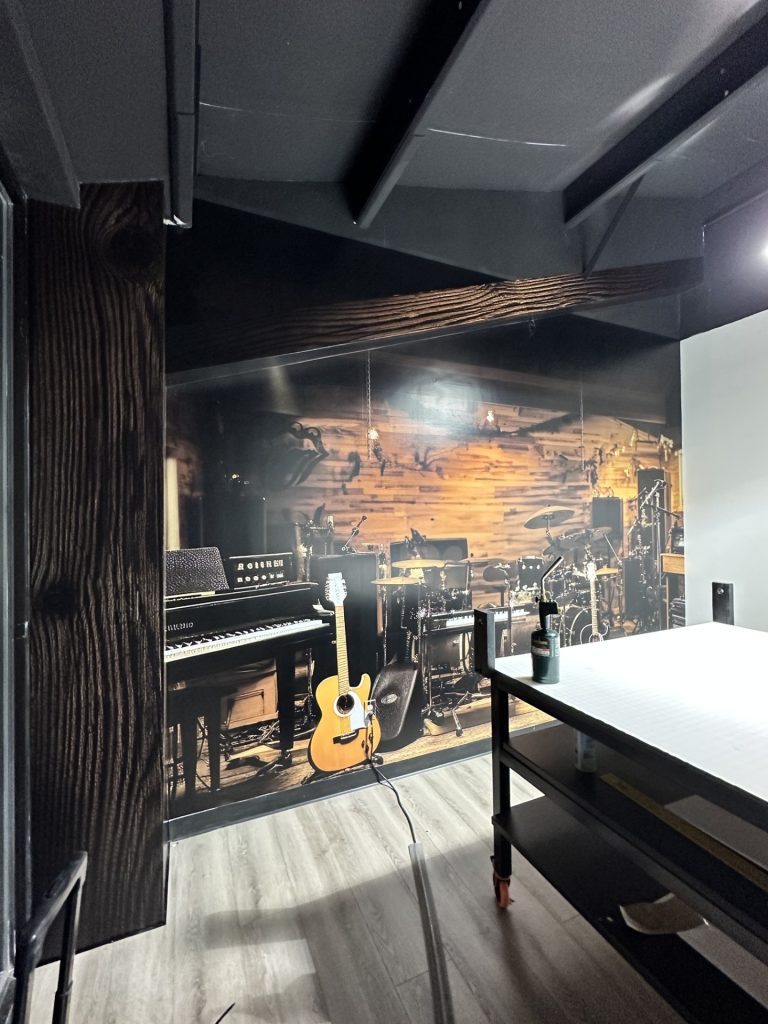 Music studio wall mural in our design studio. we also created faux beams to frame the wall.