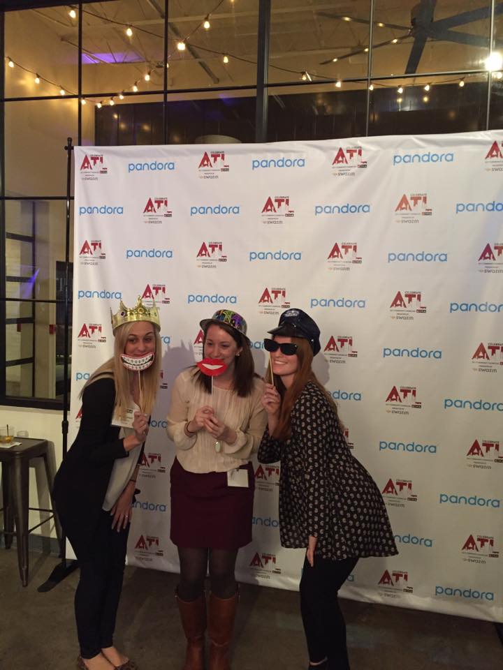 Screen featuring the ATL and pandora logos with three women posing in front with photobooth props 