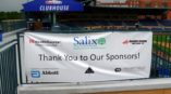 Image of a hanging sponsor banner at an outdoor non-profit event Durham, NC.