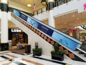Image of escalator handrail graphics, installed in a mall in Raleigh, NC.
