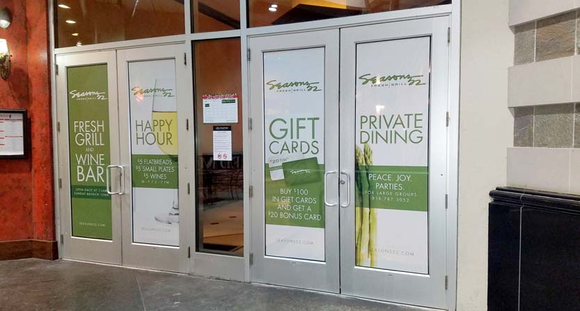 Image of perforated window graphics, installed on doors in a shopping mall in Raleigh, NC.