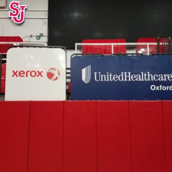 Signs for Xerox and United Healthcare Oxford in bleachers of basketball arena