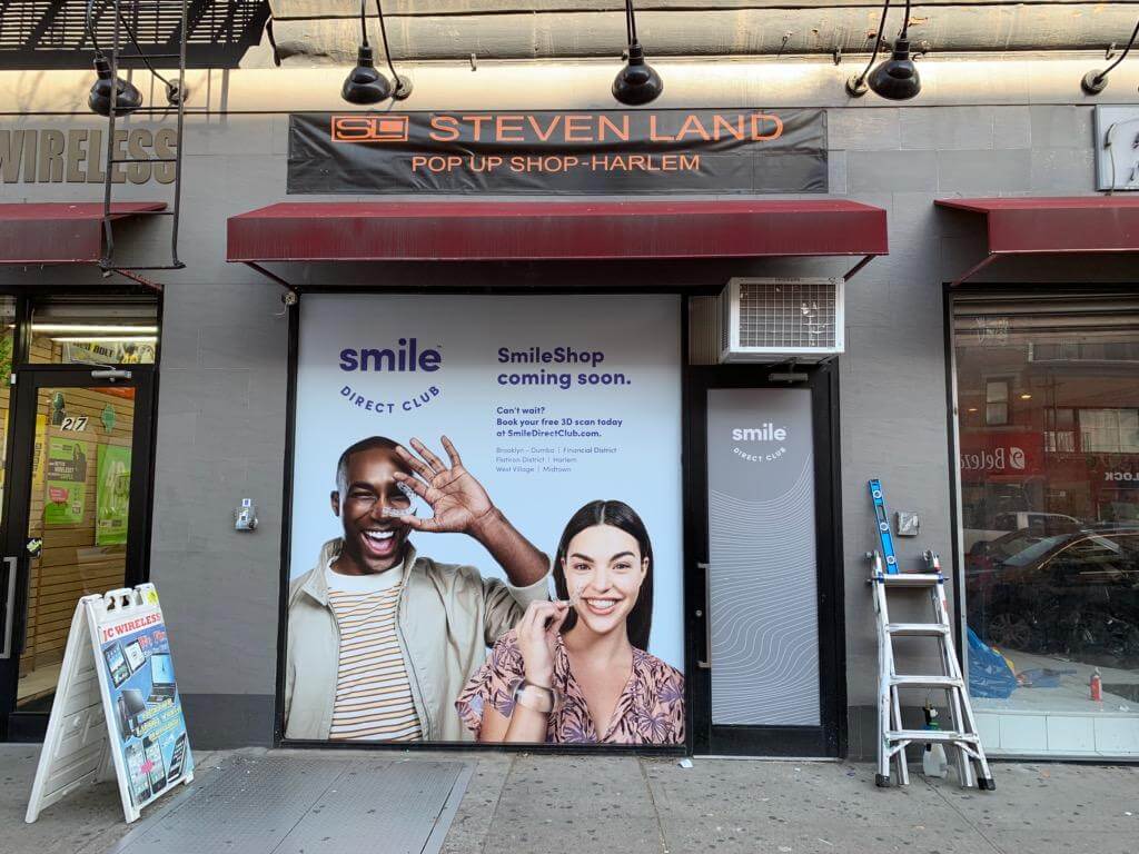 Smile Direct Club Two Models in Harlem window covering graphic