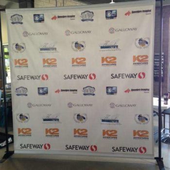 Photo backdrop banner with a variety of logos from the event sponsors