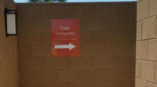 Directional signage pointing toward the trash compactor