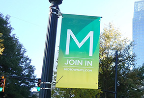 Banner hanging from a lamp post that is advertising Midtown events. 