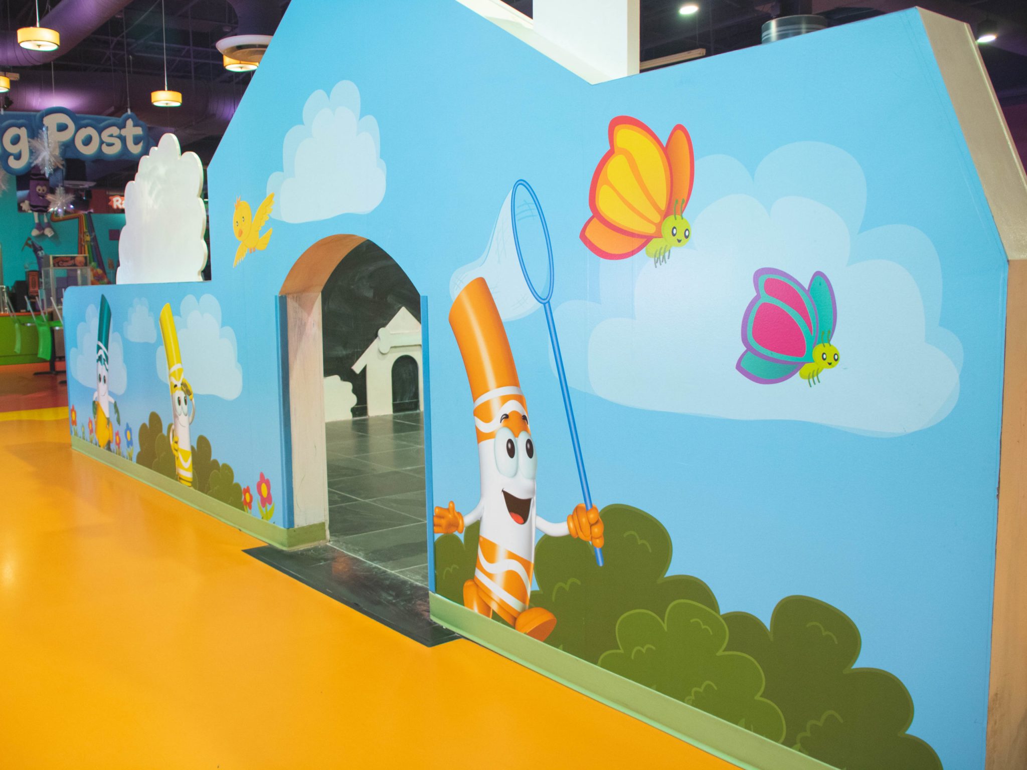 Orange wall mural of a play house, vibrant and artistic design