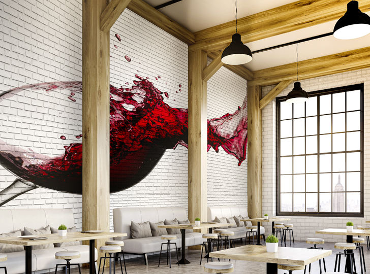 Red wine spilling decal on white brick wall in stylish restaurant dining area.