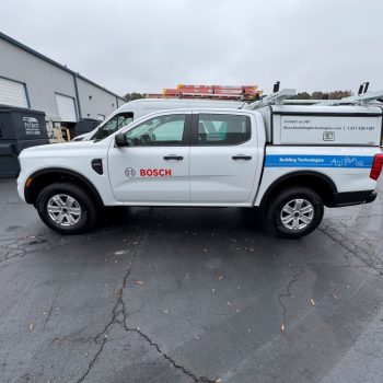 White pickup truck with partial vehicle wrap and decals on doors and bed in Raleigh, NC.