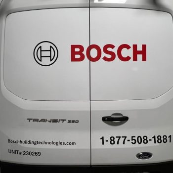 Rear view of white Ford Transit van with partial vehicle wrap lettering in Raleigh, NC.
