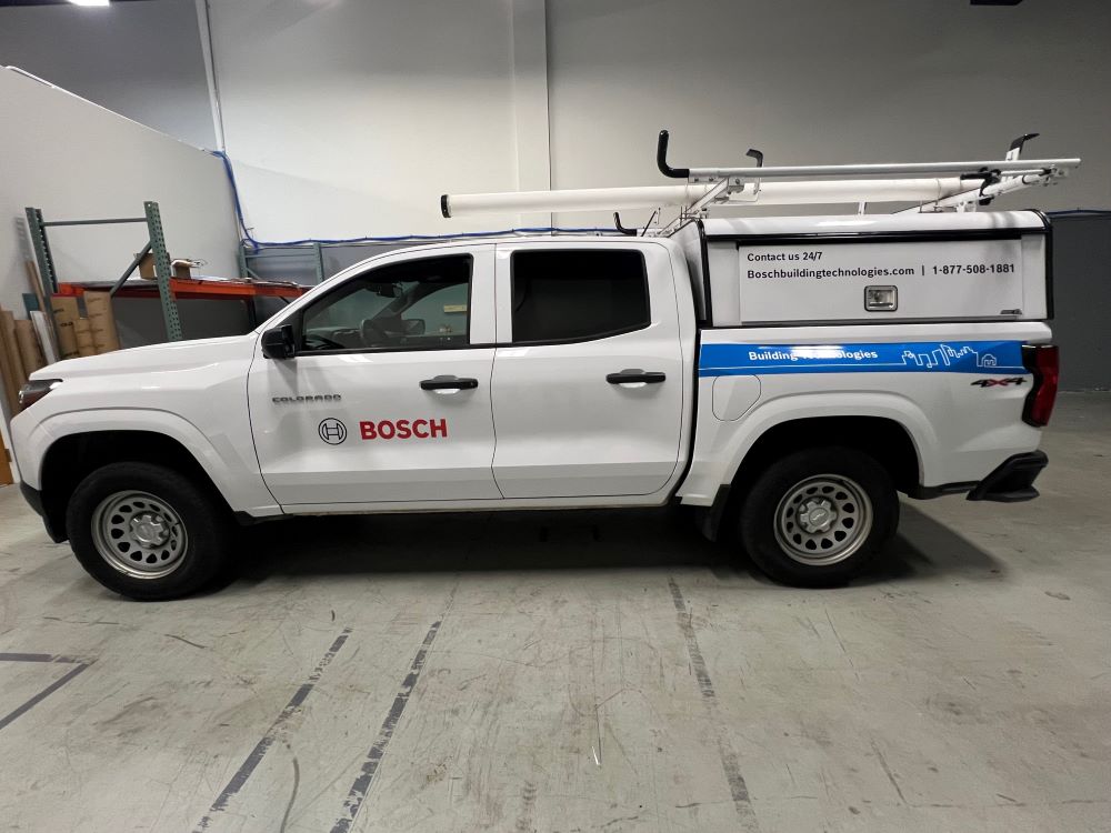 White pickup truck with partial vehicle wrap and decals in a warehouse in Raleigh, NC.