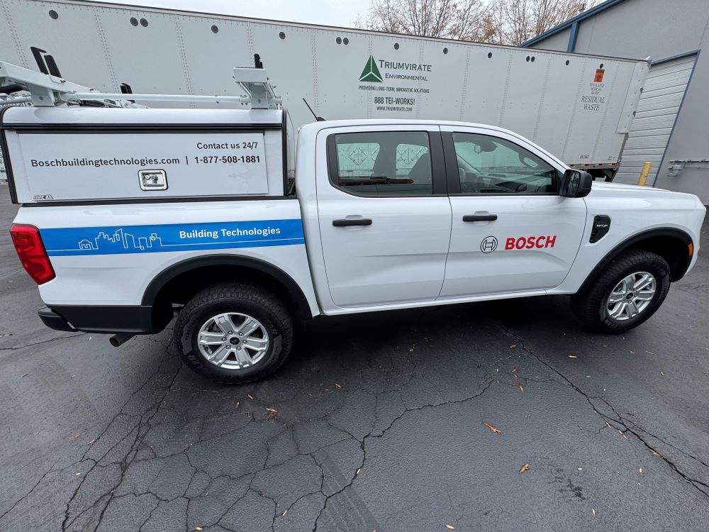 White pickup truck with partial vehicle wrap and contact information decals in Raleigh, NC.