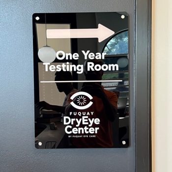 Acrylic directional wall sign with white vinyl lettering mounted on gray wall in Raleigh, NC.