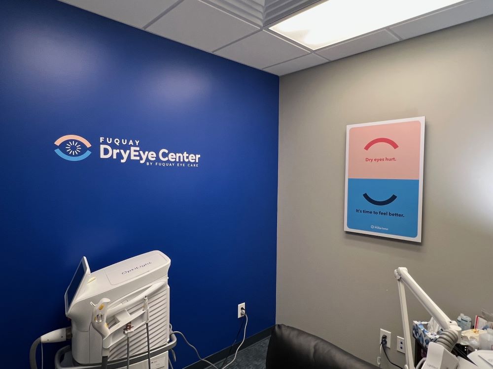 Wall-mounted vinyl logo decal on blue wall and framed poster sign on gray wall in Raleigh, NC.