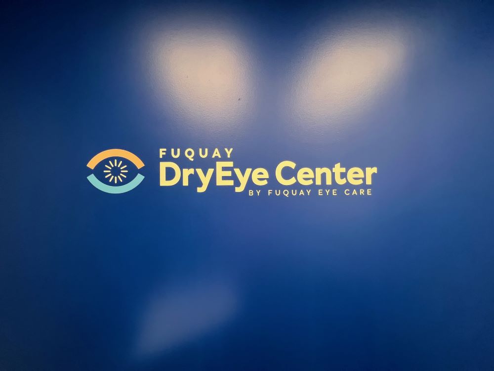 Dimensional wall sign with logo and text in yellow mounted on blue wall in Raleigh, NC.