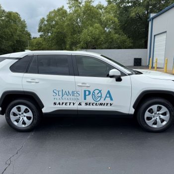 Custom vehicle graphics on a white SUV featuring safety and security branding.