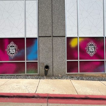 Colorful decorative window films with logos on building glass panels in Raleigh, NC.