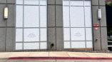 Two large commercial windows with patterned privacy window films on a gray building in Raleigh, NC.