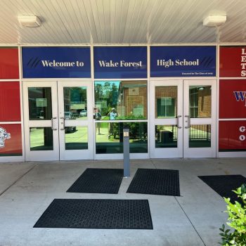 Window film graphics on glass doors and panels at a high school entrance in Raleigh, NC.