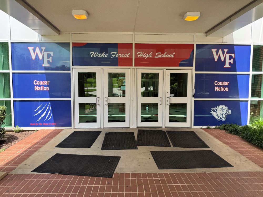 Window film graphics with school logos and colors on entrance doors in Raleigh, NC.