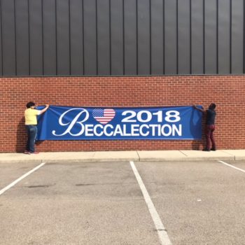 two men holding up banner sign that reads 2018 beccalection