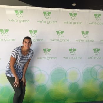 Woman standing in front of Virginia Lottery trade show backdrop