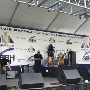 White Syracuse Behavioral Healthcare step and repeat banner on concert stage