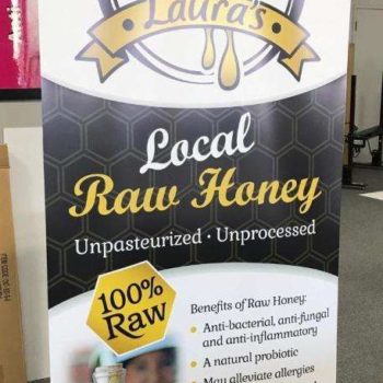 Laura's local raw honey informational standing banner with benefits
