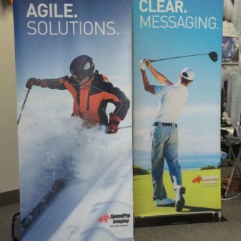Two retractable banner stands with someone skiing and someone playing golf