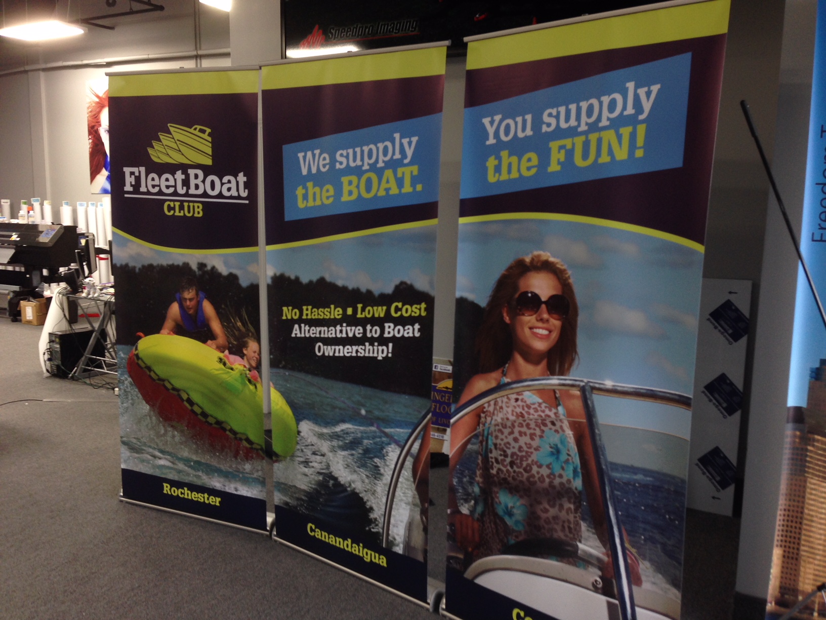 Three Fleet Boat Club banner stands with phrase we supply the boat you supply the fun